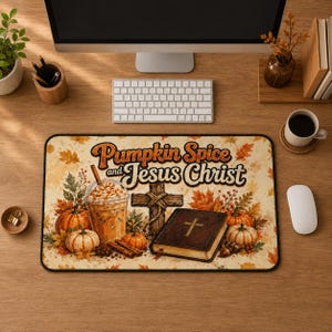Può includere: Un tappetino da scrivania rettangolare con un design autunnale e il testo Pumpkin Spice and Jesus Christ. L'illustrazione include un bicchiere di caffè freddo, una croce di legno, un libro marrone chiuso con una croce e zucche arancioni.