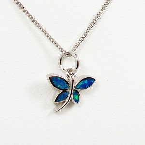 Pode incluir: Um colar de corrente de prata com um pingente de libélula de opala azul.