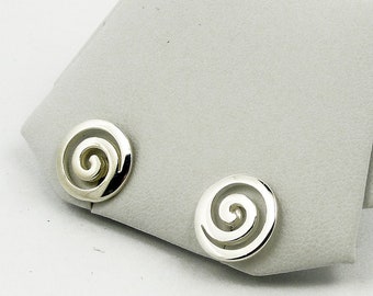 May include: A pair of silver earrings with a spiral design. The earrings are on a white display stand.