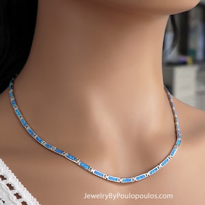 Könnte beinhalten: Eine silberne Halskette mit blauen Opal-Steinen. Die Halskette befindet sich auf einer weißen Puppe.