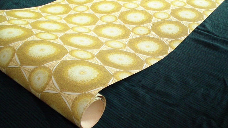 May include: A roll of wallpaper with a repeating pattern of yellow and white circles. The circles are arranged in a geometric pattern and have a slightly textured surface.