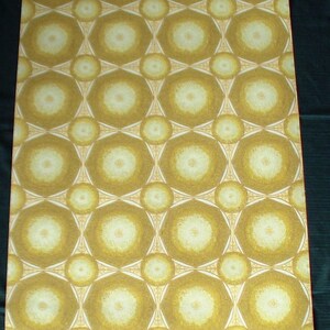 May include: A close-up of a wallpaper with a repeating pattern of white circles with a yellow center, surrounded by a brown geometric design. The wallpaper has a textured surface.