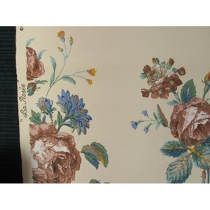 May include: A vintage floral wallpaper with a cream background and a repeating pattern of blue, brown, and yellow flowers. The wallpaper has the text "La Rosi&eacute;" printed on the side.