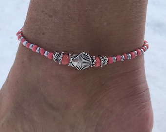 May include: A pink and silver beaded anklet with a seashell charm.
