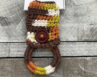 May include: Handmade crocheted towel holder with a brown button and a multi-colored striped ring. The tag reads "Handmade Towel Holder".