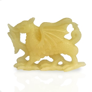 May include: A yellow dragon figurine with wings outstretched, standing on a base. The dragon is made of a translucent material and has a detailed design.