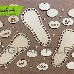 May include: A set of wooden laser cut shapes for crafting. The shapes include oval tags with names like "Sten Andre", "Dan Mirko", "Georg Matthias", "Brita Elis", "Helena Caroly", "Karl", and "Oskar". There are also two larger shapes that look like feet with holes around the edges.