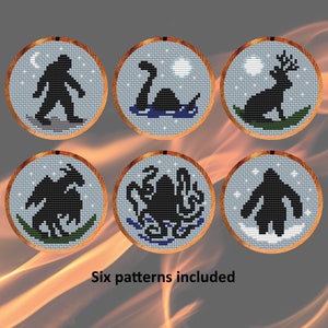 Könnte beinhalten: Sechs Stickmuster mit mythischen Kreaturen, darunter ein Bigfoot, ein Seeungeheuer, ein Hirsch, ein Drache, ein Oktopus und ein Bigfoot. Die Muster sind in runden Stickrahmen dargestellt.