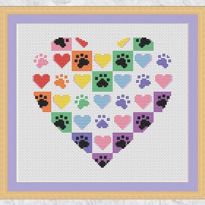 May include: A colorful cross-stitch pattern in the shape of a heart, featuring paw prints and hearts in various shades of red, orange, yellow, green, blue, purple, and pink.