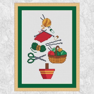 May include: Cross stitch pattern of a Christmas tree made of yarn balls, needles, scissors, and a basket of yarn. The tree is decorated with a red and white striped pot at the bottom.