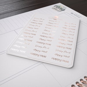 May include: A sheet of stickers with the words "Happy Mail" repeated in a rose gold colour on a white background.