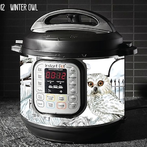 May include: White Instant Pot with a snowy owl design. The owl is perched on a branch with a snowy background. The Instant Pot has a digital display showing the time 08:38.