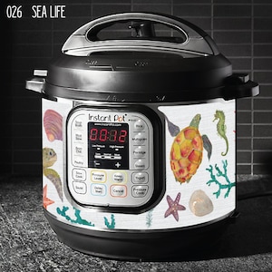 May include: White Instant Pot with a sea life design. The design features a sea turtle, starfish, seahorse, and seaweed. The Instant Pot has a digital display that reads "88:88".