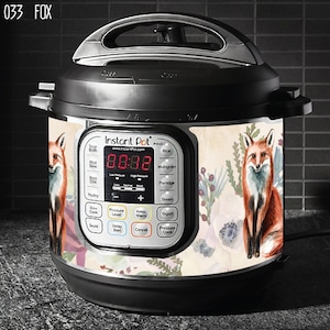 Puede incluir: Una olla a presión Instant Pot blanca con un diseño floral y un zorro. La pantalla digital muestra "88:88".