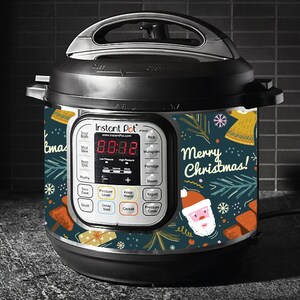 May include: Black Instant Pot with a Christmas-themed wrap. The wrap features Santa Claus, gift boxes, and the text "Merry Christmas!" on a dark teal background. The appliance has a digital display showing the time.