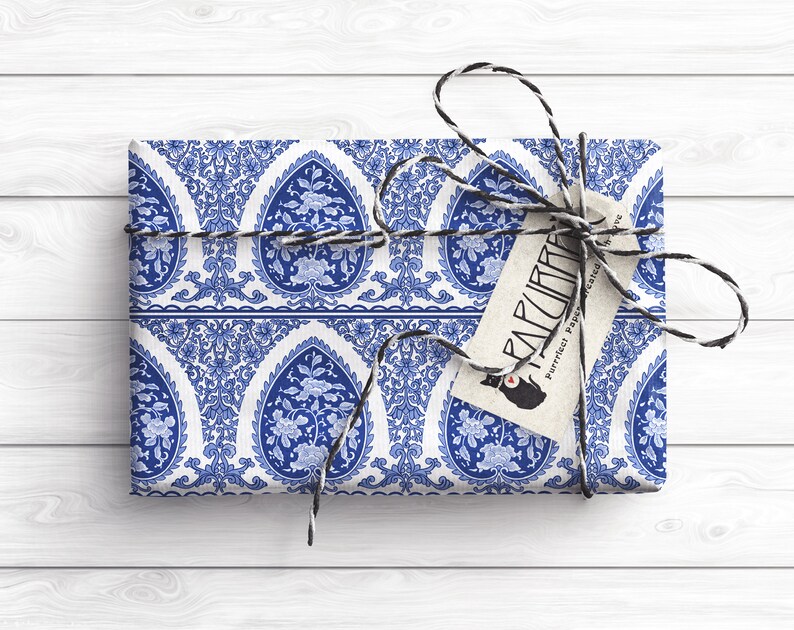 May include: A blue and white patterned gift box wrapped with twine and a tag that says "PARLOR" with a cat logo and the text "Perfect Paper for Presents".