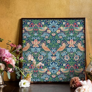 May include: A framed print of a vintage floral pattern with birds and berries. The pattern is in shades of blue, green, pink, and orange. The frame is a dark brown wood.
