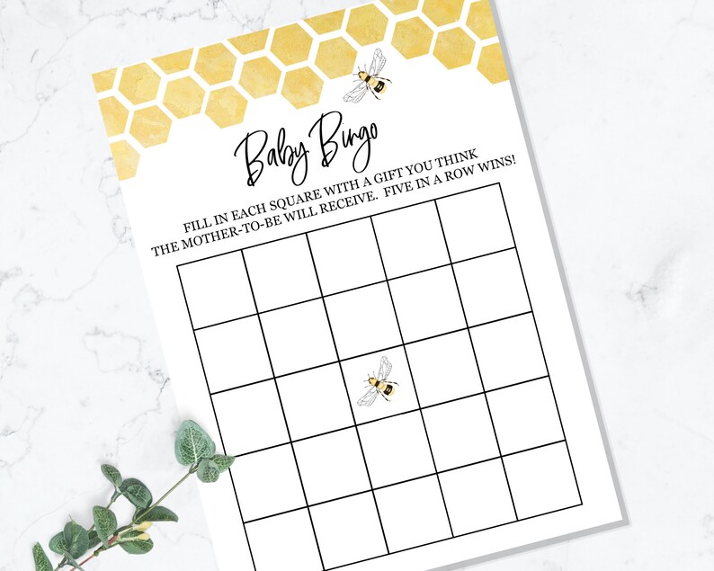 May include: A printable baby shower bingo card with a honeycomb pattern and bee illustrations. The text reads "Baby Bingo" and "Fill in each square with a gift you think the mother-to-be will receive. Five in a row wins!"