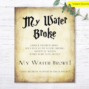 May include: A printable sign with a vintage parchment background and black text that reads "My Water Broke!" with instructions for a game. The text says "Grab a frozen baby and put it in your drink. When it melts make sure you shout "My Water Broke!" First broken water wins a prize!"