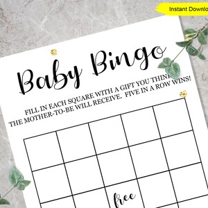 May include: A printable baby bingo card with a black and white grid and the text "Baby Bingo" at the top. The text below the grid reads "Fill in each square with a gift you think the mother-to-be will receive. Five in a row wins!" and "free" is written in the centre square.