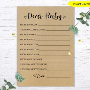 May include: A printable baby shower game card with the text "Dear Baby" and a list of things the guest hopes the baby will learn, love, get, laugh, become, always, remember, and get from their mom and dad. The card has a brown background and a heart design.