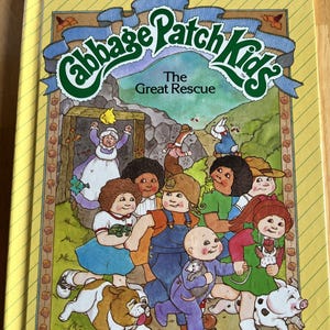 May include: A white ceramic mug with a black handle and the text "But First, Coffee" in a black, handwritten-style font. The mug is on a white surface.