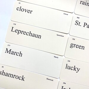 May include: A collection of off-white rectangular cards featuring black printed text and numerical identifiers. Visible words include gold, clover, leprechaun, march, shamrock, rain, St. Pa, green, lucky, Ireland, and parade, each with a corresponding number.