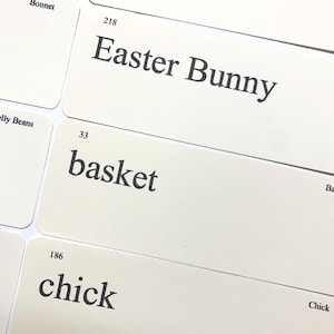 May include: A collection of rectangular white cards featuring black printed text. Visible words include Bonnet, Easter Bunny with the number 218, basket with the number 33, chick with the number 186, and the word Chick. The cards are arranged in a grid.