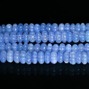 May include: A strand of light blue chalcedony beads. The beads are round and have a slightly bumpy texture.