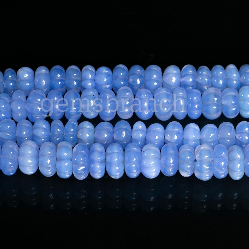 May include: A strand of light blue chalcedony beads. The beads are round and have a slightly bumpy texture.