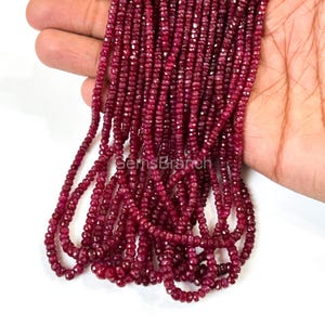 May include: Strands of faceted, deep red ruby beads. The beads are small and uniform in size, strung together to create a flowing, textured appearance. The image is well-lit, highlighting the rich color and sparkle of the gemstones. The text "GemsBranch" is visible.
