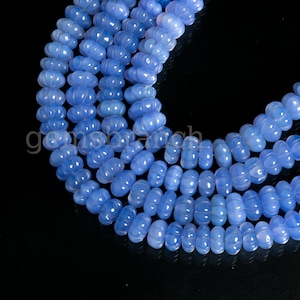 May include: A strand of light blue chalcedony beads with a faceted, pumpkin-shaped design.