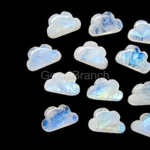 May include: A selection of cloud-shaped moonstone gemstones. The stones are white with blue and iridescent flashes, set against a black background. The text "Gems Branch" is visible.