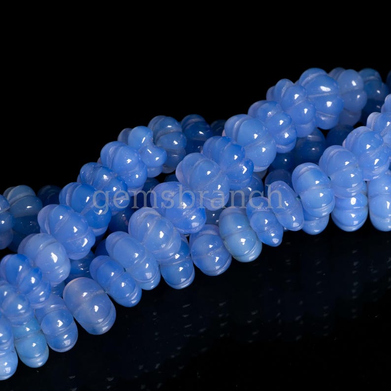 May include: A strand of blue chalcedony beads, each bead is shaped like a flower with multiple rounded petals.