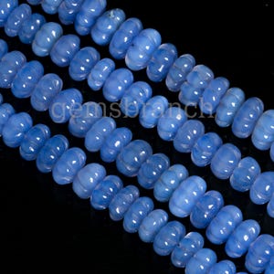 May include: A strand of light blue gemstone beads with a faceted, pumpkin-shaped design. The beads are strung together on a clear thread.