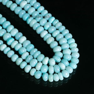 Puede incluir: Una hebra de cuentas de piedras preciosas de color azul claro. Las cuentas son de forma ovalada y tienen un acabado liso y pulido.