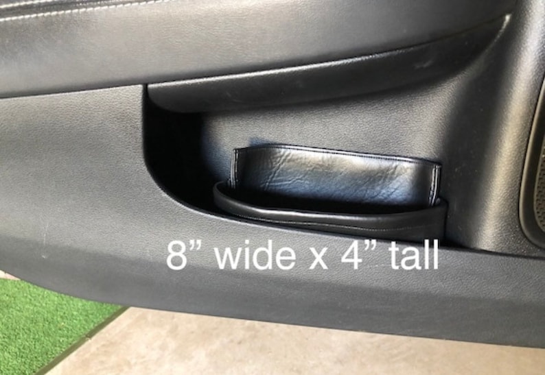 May include: Black leather car door organizer with a 8" wide x 4" tall measurement.