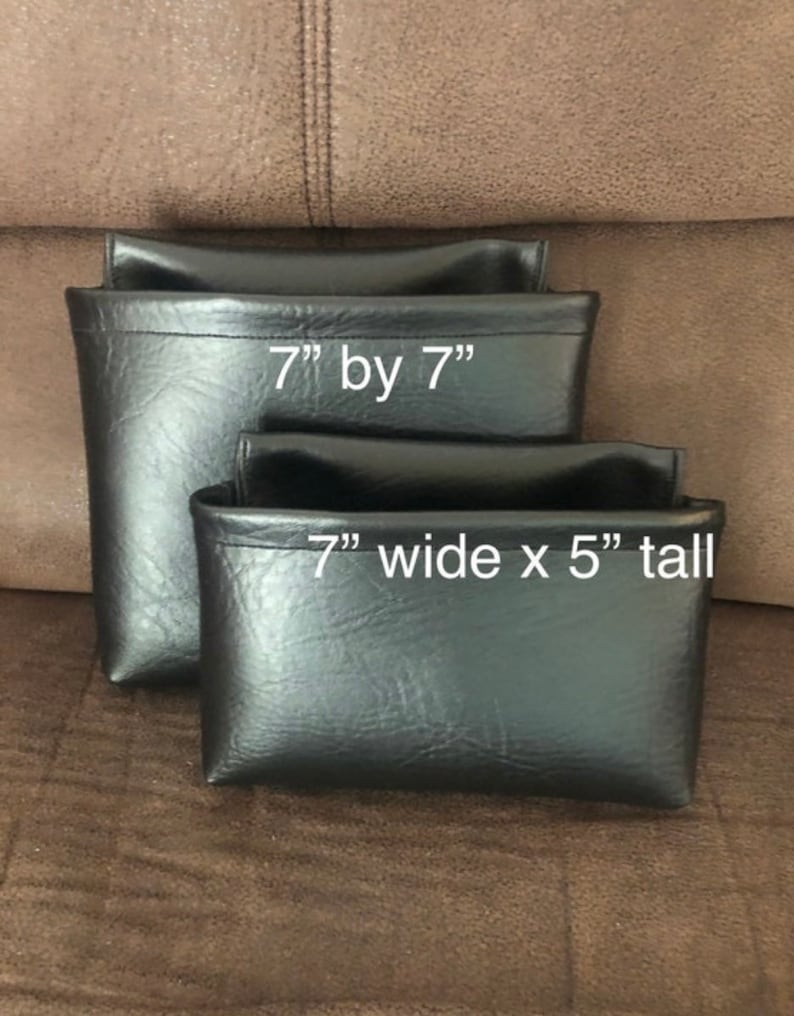May include: Two black leatherette pouches. The larger pouch measures 7 inches by 7 inches. The smaller pouch measures 7 inches wide by 5 inches tall.