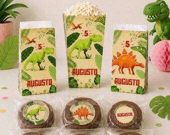 May include: A party set featuring a banner spelling AUGUSTO, three paper treat bags with dinosaur graphics and the name AUGUSTO, and six individually wrapped round chocolate treats with dinosaur and number 5 stickers, all in a jungle theme.