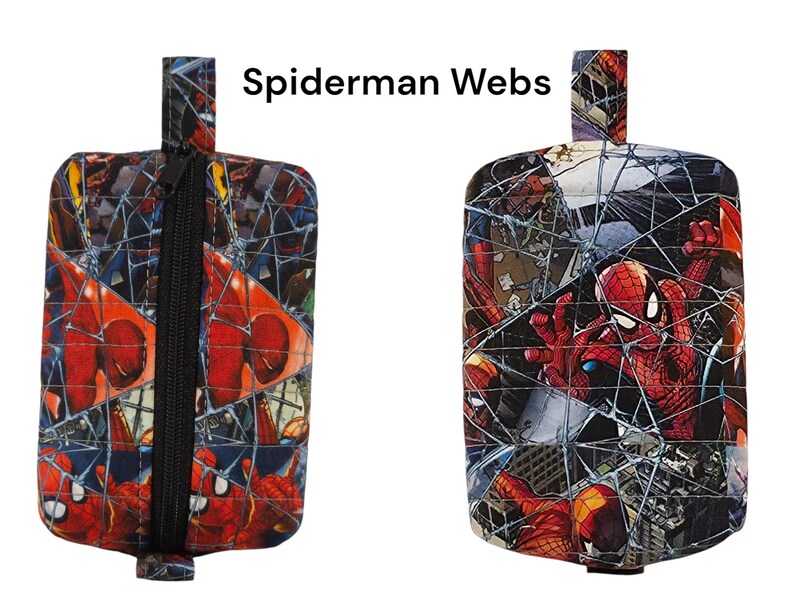 以下が含まれることがあります： 赤と青のスパイダーマンのキャラクタープリントと白いクモの巣模様が特徴の長方形の布製ポーチ。ポーチには黒いファスナーと上部に布製のループが付いています。アイテムの上部には「Spiderman Webs」というテキストが印刷されています。