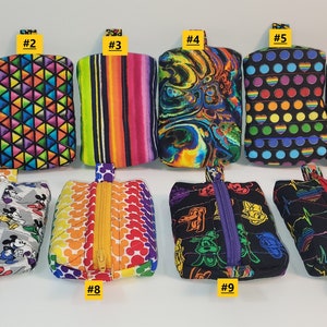 May include: Ten small zippered pouches with various colorful patterns, including rainbow stripes, polka dots, and geometric designs. Each pouch is numbered from 1 to 10.