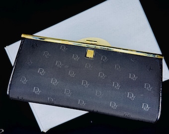 Clutch vintage Christian Dior com monograma e moldura em canvas, modelo Les Sacs, década de 1970, preta, para noite, com ferragens douradas e caixa original.