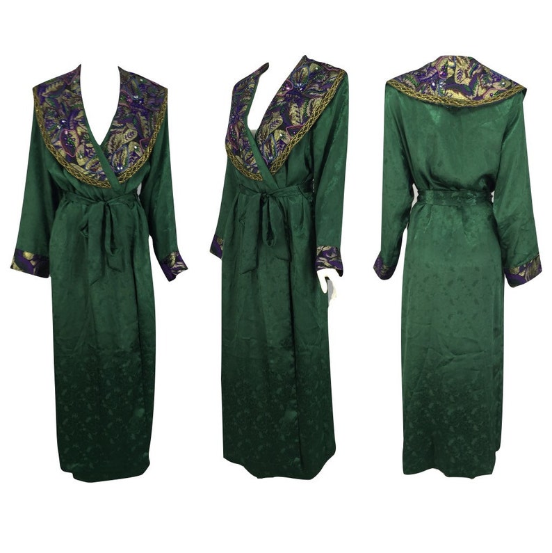 May include: A long, emerald green robe with a V-neck and long sleeves. The collar and cuffs are adorned with gold, purple, and green embellishments. A matching belt cinches the waist. The robe is displayed from multiple angles.