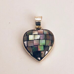 Peut inclure: Un pendentif en argent en forme de cœur avec une mosaïque de carrés noirs, blancs et nacrés.