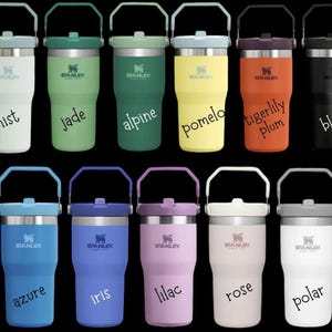 May include: Twelve Stanley brand insulated tumblers with handles in various colors, including mist, jade, alpine, pomelo, tigerlily plum, black, azure, iris, lilac, rose, and polar.