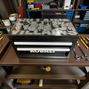 May include: Black Kobalt tool chest with three drawers and the word "KOBALT" in white. The top of the chest features the words "VILLAINS" and images of cartoon villains in silver.