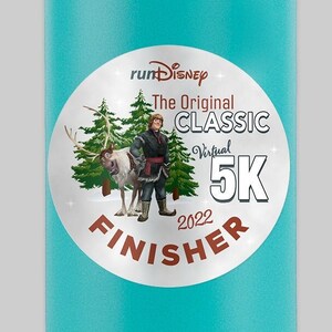 May include: A turquoise blue water bottle with a black lid and handle. The bottle has a white sticker with a runDisney logo, the text "The Original Classic Virtual 5K 2022 Finisher" and an image of a cartoon character.