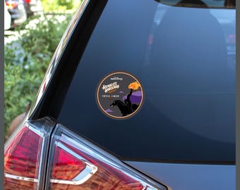 May include: A circular sticker adhered to a car window featuring a graphic of the Headless Horseman riding a black horse and holding a glowing orange pumpkin. The text reads runDisney Headless Horseman Pursuit Virtual 4-Miler 2021.