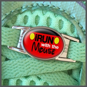 May include: A silver shoe charm with a red and black oval-shaped design. The charm features the text "I RUN with the MOUSE" in white lettering and two yellow circles.