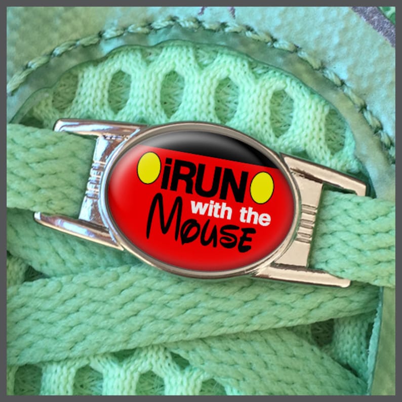 May include: A silver shoe charm with a red and black oval-shaped design. The charm features the text "I RUN with the MOUSE" in white lettering and two yellow circles.